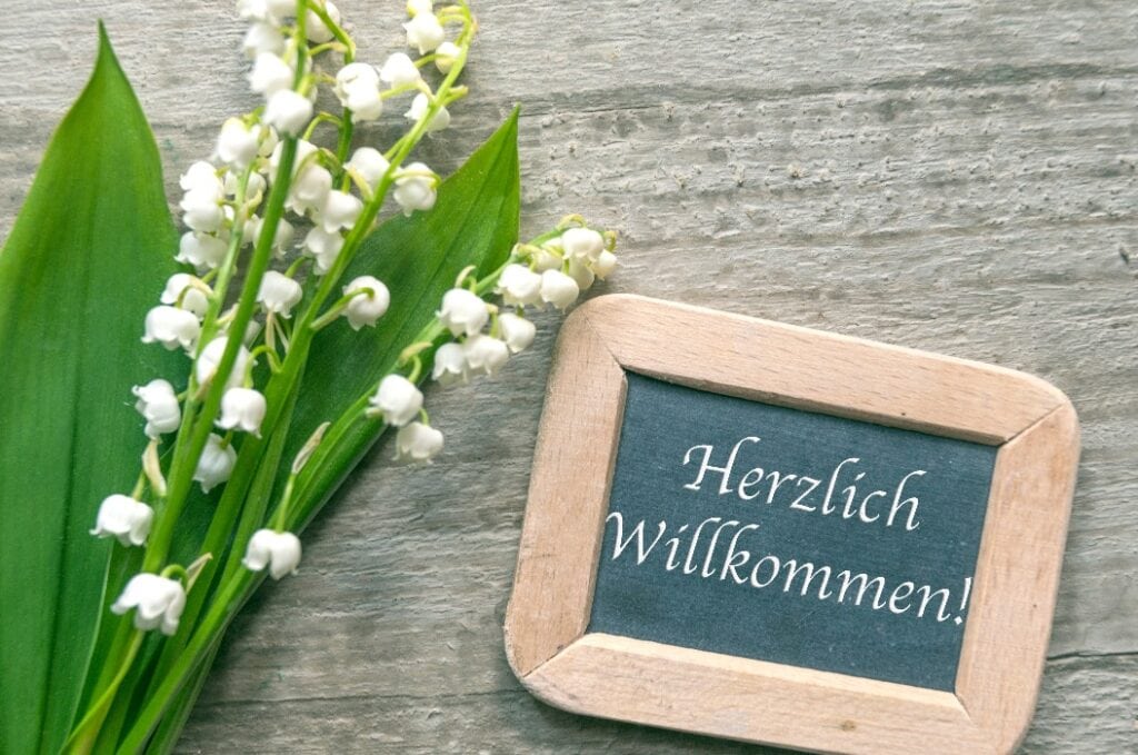 Herzlich Willkommen, kleine Tafel mit Maiglöckchen